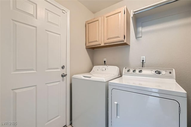 clothes washing area with cabinets and separate washer and dryer