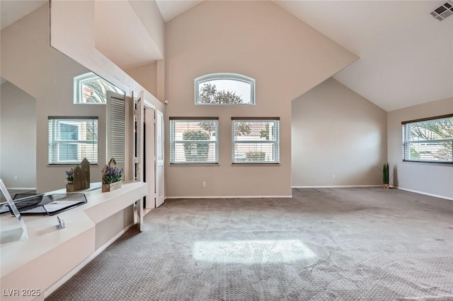 interior space featuring visible vents, baseboards, and high vaulted ceiling