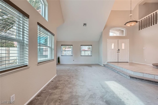 entryway with visible vents, a high ceiling, carpet, and baseboards