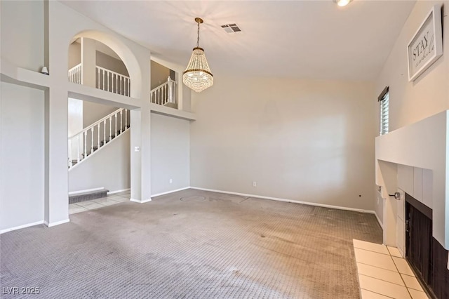 unfurnished living room with visible vents, baseboards, stairway, light colored carpet, and a high ceiling