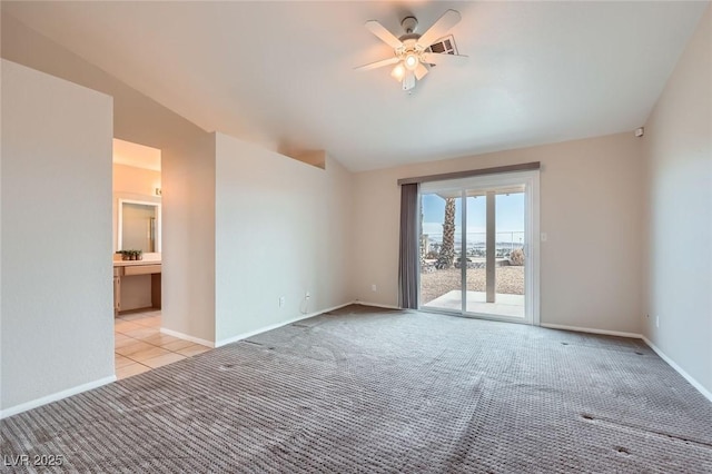 carpeted spare room featuring baseboards, lofted ceiling, and a ceiling fan