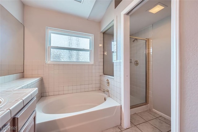 full bathroom featuring tile patterned flooring, a stall shower, a bath, and vanity