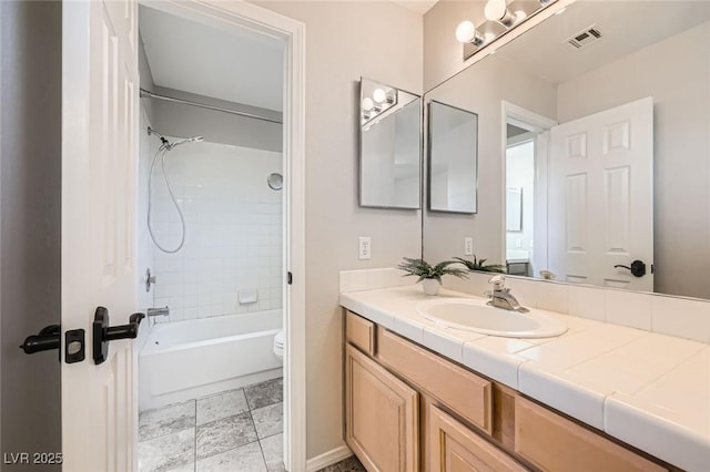 bathroom with visible vents, toilet, vanity, and shower / tub combination