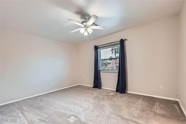 empty room with baseboards, light carpet, and a ceiling fan