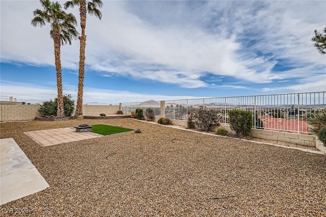 view of yard with a patio, a fenced backyard, and an outdoor fire pit