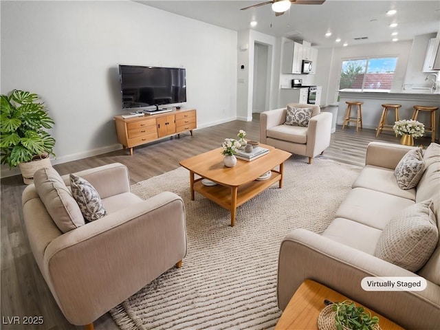 living room featuring ceiling fan and light hardwood / wood-style floors