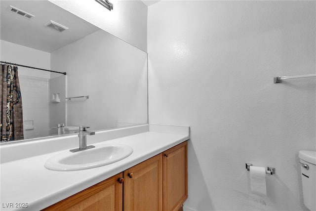 bathroom featuring vanity, curtained shower, and toilet