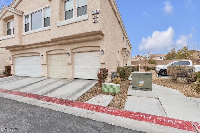 9323 Leaping Deer Pl Unit 102, Las Vegas, NV 89178 - townhome / multi-family property with a garage, stucco siding, and driveway