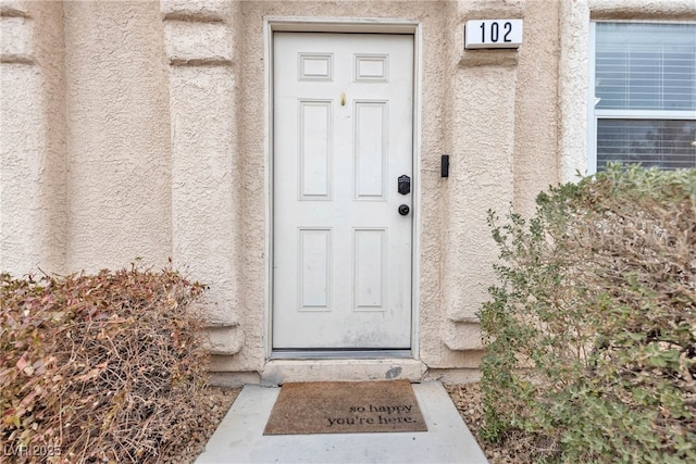 entrance to property featuring stucco siding