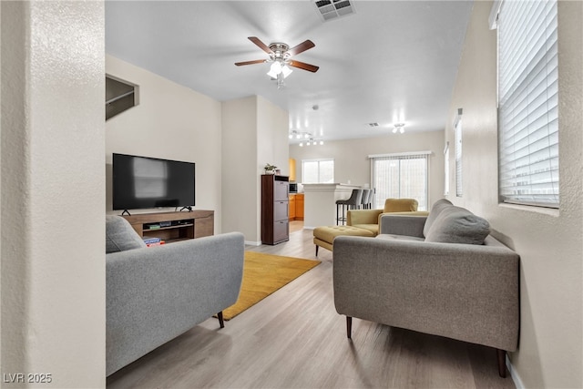 living room with ceiling fan and light hardwood / wood-style floors