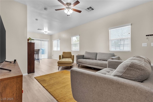 living room featuring ceiling fan and light hardwood / wood-style flooring