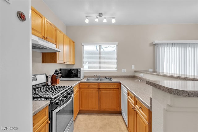 9323 Leaping Deer Pl Unit 102, Las Vegas, NV 89178 - kitchen with under cabinet range hood, appliances with stainless steel finishes, a sink, a peninsula, and light tile patterned floors