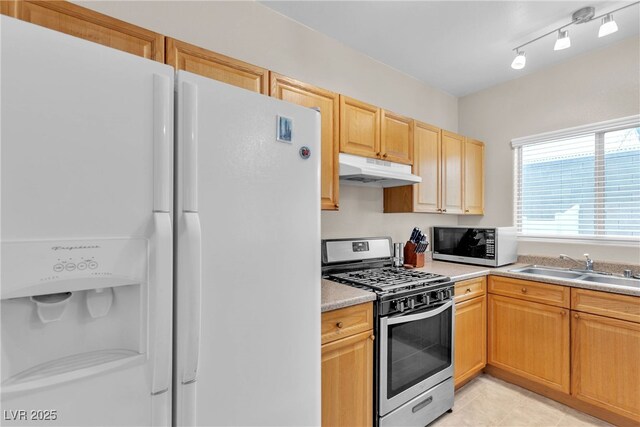 kitchen featuring under cabinet range hood, a sink, white fridge with ice dispenser, light countertops, and gas range