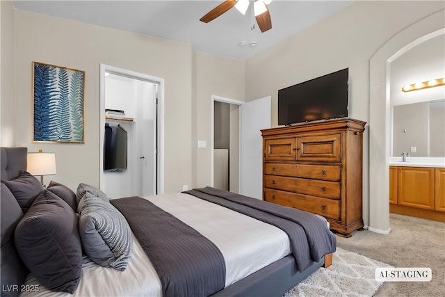 9323 Leaping Deer Pl Unit 102, Las Vegas, NV 89178 - bedroom featuring light carpet, a walk in closet, a sink, ensuite bathroom, and a closet
