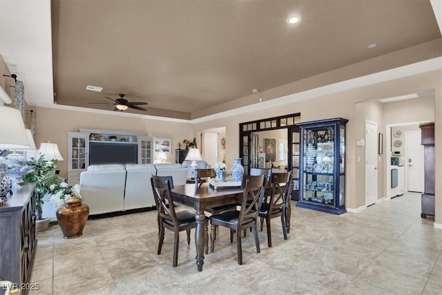 dining room with a raised ceiling and ceiling fan