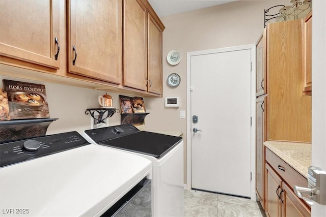 clothes washing area with cabinets and separate washer and dryer