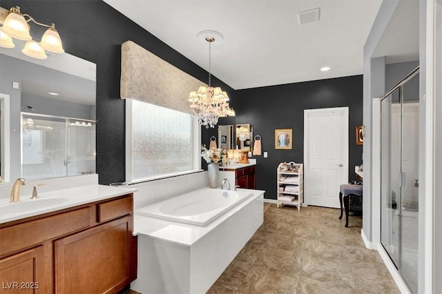 bathroom featuring a notable chandelier, plus walk in shower, and vanity