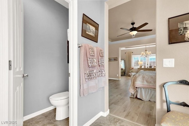 bathroom featuring ceiling fan with notable chandelier, toilet, and hardwood / wood-style flooring