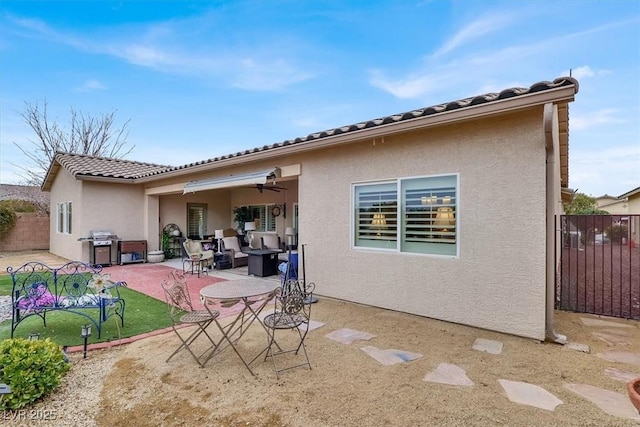 back of property with an outdoor living space, a patio, and ceiling fan