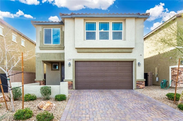 view of front of property featuring decorative driveway, an attached garage, and stucco siding