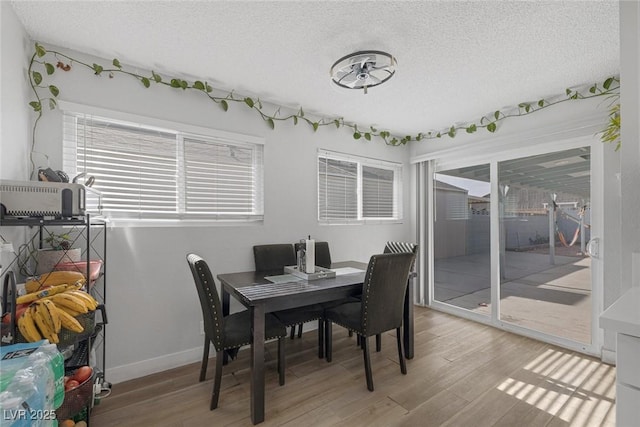 dining area with hardwood / wood-style flooring and a textured ceiling