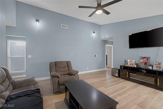 living room with high vaulted ceiling, ceiling fan, and light hardwood / wood-style flooring