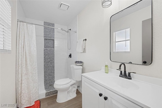 bathroom with hardwood / wood-style flooring, vanity, a shower with shower curtain, and toilet