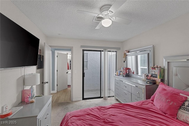 bedroom with ceiling fan, access to exterior, light carpet, and a textured ceiling