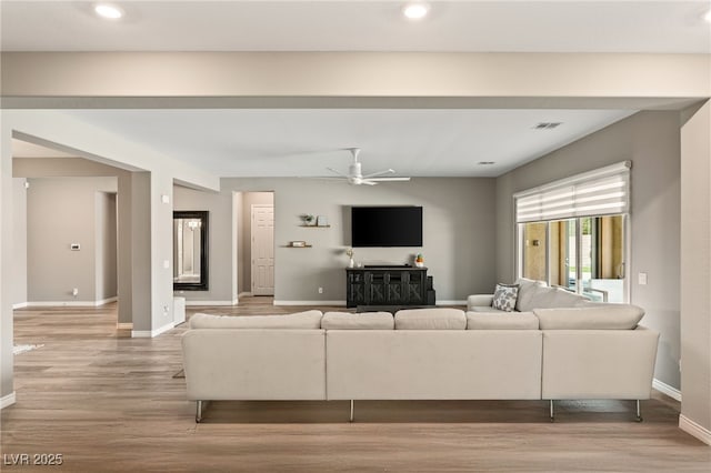 living room featuring ceiling fan and light hardwood / wood-style floors