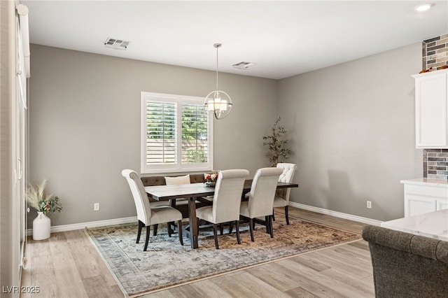 dining space featuring an inviting chandelier and light hardwood / wood-style floors