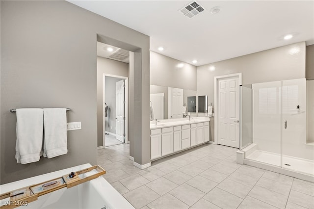 bathroom featuring walk in shower, vanity, and tile patterned flooring