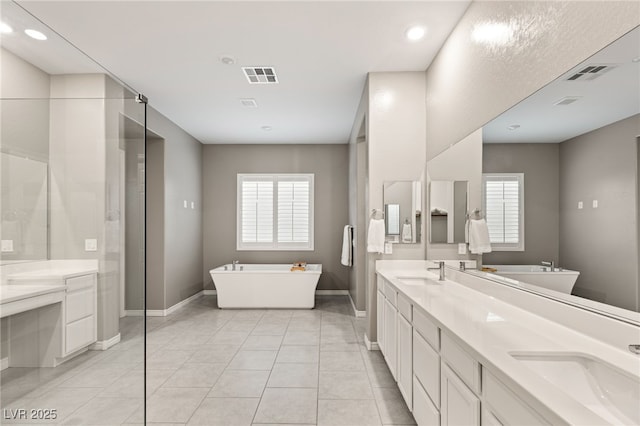 bathroom with vanity, tile patterned flooring, plenty of natural light, and a tub