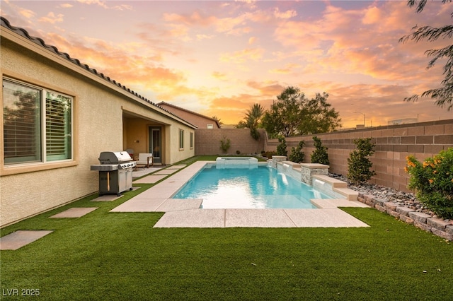 pool at dusk featuring pool water feature, grilling area, a patio area, and a lawn