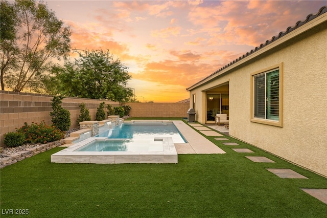 pool at dusk featuring a lawn, an in ground hot tub, and a patio area