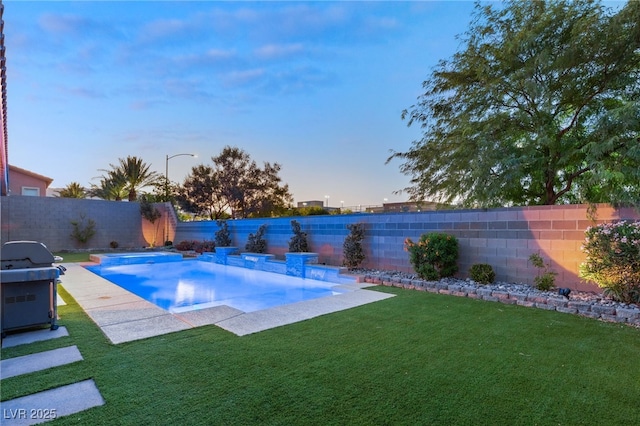 pool at dusk with a yard and a patio area