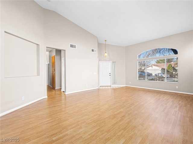 unfurnished living room featuring high vaulted ceiling and light hardwood / wood-style floors