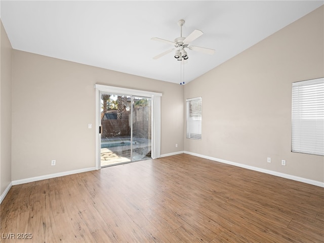 empty room with hardwood / wood-style flooring, vaulted ceiling, and ceiling fan