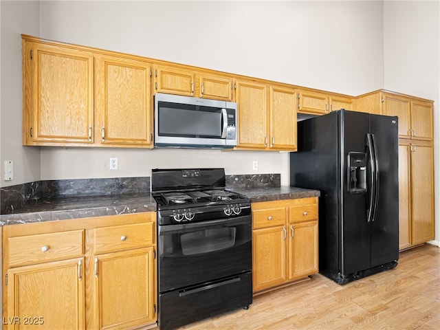 kitchen featuring light wood-type flooring and black appliances