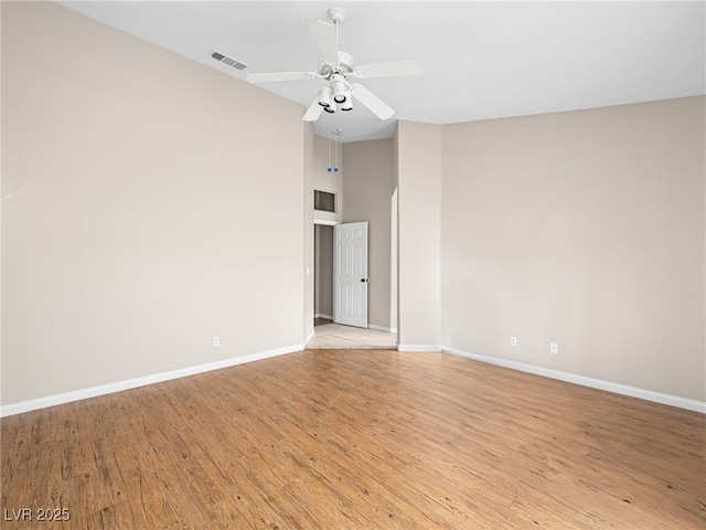 empty room featuring high vaulted ceiling, ceiling fan, and light wood-type flooring