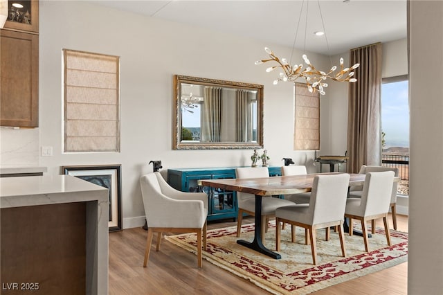 dining space featuring an inviting chandelier and light hardwood / wood-style flooring