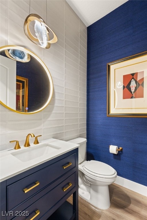 bathroom with hardwood / wood-style flooring, vanity, tasteful backsplash, and toilet