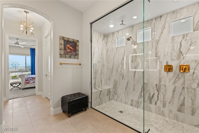 bathroom with a tile shower, tile patterned floors, and an inviting chandelier