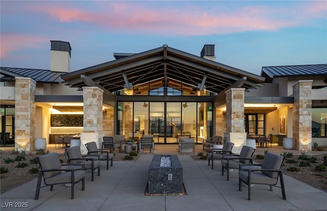 back house at dusk featuring a patio area