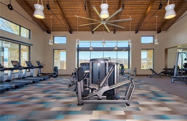 workout area featuring a high ceiling, wood ceiling, and dark carpet