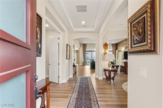 entryway with a raised ceiling and light hardwood / wood-style floors