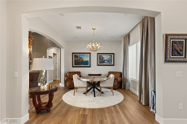 dining room with hardwood / wood-style flooring and a chandelier