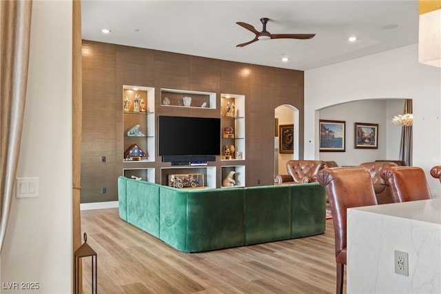 living room featuring hardwood / wood-style floors, built in features, and ceiling fan