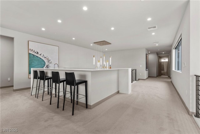 kitchen featuring recessed lighting, visible vents, baseboards, light countertops, and hanging light fixtures