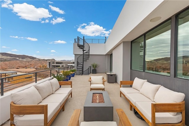 view of patio / terrace featuring stairs, an outdoor living space with a fire pit, and a mountain view