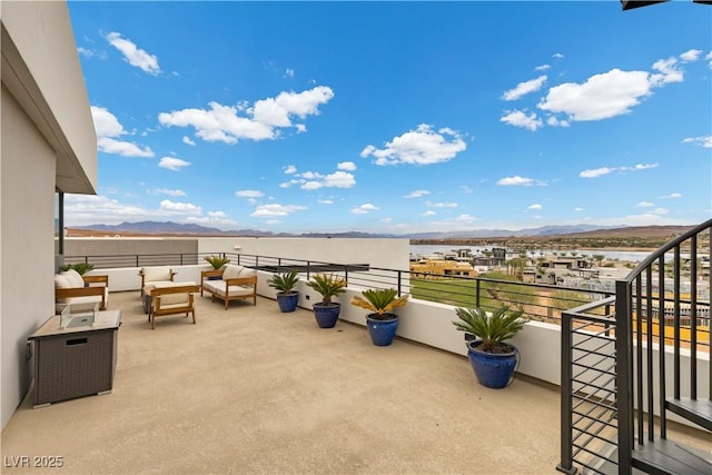 view of patio with outdoor lounge area, a mountain view, and a balcony